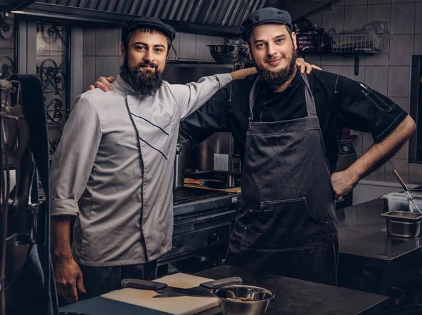 Dos Cocineros Barbudos Amigos Vestidos Con Uniformes Sombreros Abrazan Mientras — Foto de Stock