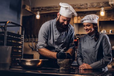 Şef susam tohumu ekmek yemek pişirmek için bir harç içinde biler. Şef Yardımcısı fırın ekmek pişirmeye öğretim.