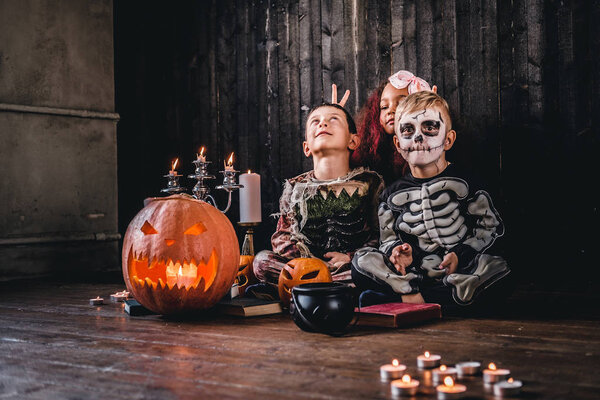 Группа милых многорасовых детей в страшных костюмах во время Хэллоуинской вечеринки в старом доме
.