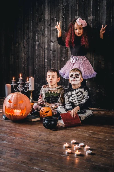 Grupo de crianças multirraciais bonitos em trajes assustadores durante a festa de Halloween em uma casa velha . — Fotografia de Stock