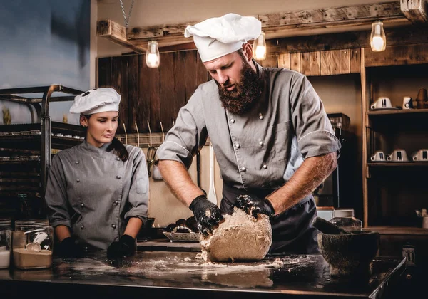 Szef kuchni, wyrabiania ciasta w kuchni. Szef kuchni nauczania jego asystent do wypieku chleba w piekarni. — Zdjęcie stockowe