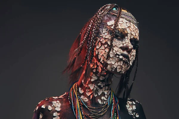 Porträt einer furchterregenden afrikanischen Schamanin mit versteinerter rissiger Haut und Dreadlocks. Make-up-Konzept. — Stockfoto