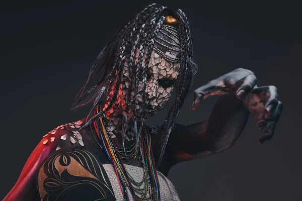 Korkunç bir Afrika şaman taşlaşmış çatlak deri ve dreadlocks ile. Makyaj konsepti.