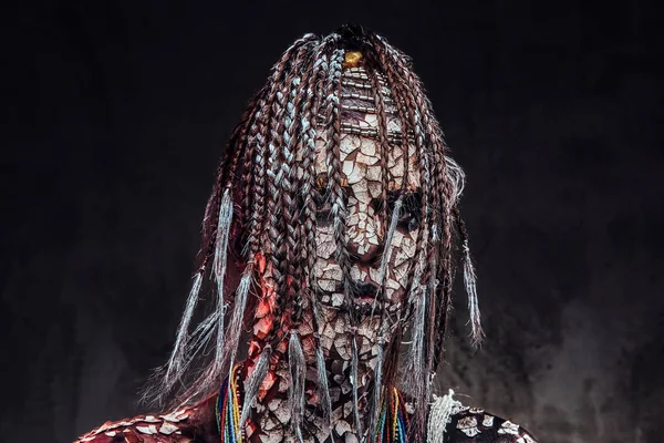 Portret van een enge Afrikaanse Sjan vrouw met een versteende gebarsten huid en dreadlocks. Make-up concept. — Stockfoto