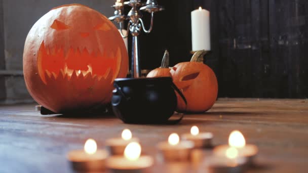 Gruselige Kürbisse und Kerzen auf einem Holzboden in einem alten Haus. — Stockvideo