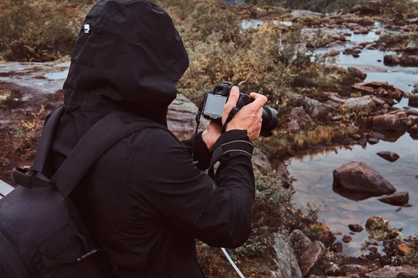 Doğa fotoğrafçı turist ile fotoğraf makinesi dağ dururken ateş eder. — Stok fotoğraf