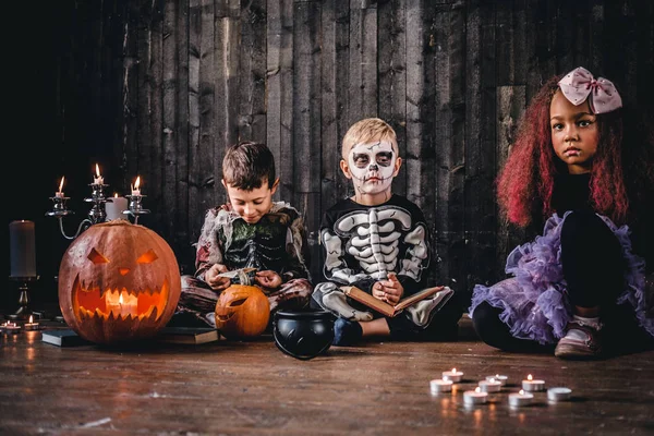 Grupp söt multiracial kids i skrämmande kostymer under Halloween-fest i ett gammalt hus. — Stockfoto