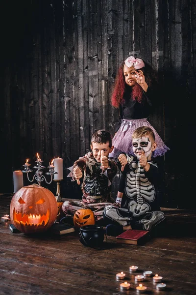 Grupp söt multiracial kids i skrämmande kostymer under Halloween-fest i ett gammalt hus. — Stockfoto