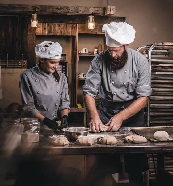 Szef kuchni nauczania jego asystent do wypieku chleba w piekarni. — Zdjęcie stockowe