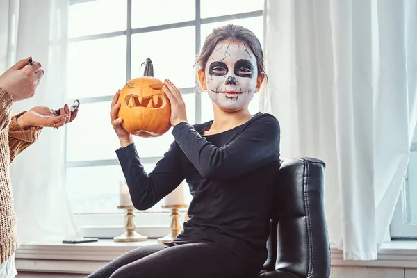 Mãe pintura filha rosto para festa de Halloween . — Fotografia de Stock