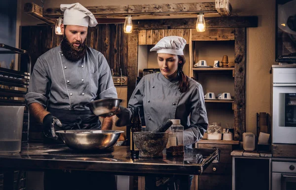 Chef teaching his assistant to bake the bread in the bakery.