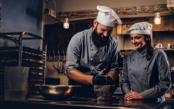 Şef susam tohumu ekmek yemek pişirmek için bir harç içinde biler. Şef Yardımcısı fırın ekmek pişirmeye öğretim.