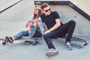 Kaykaylar skatepark, oturan genç patenciler şık giyimli kaç.