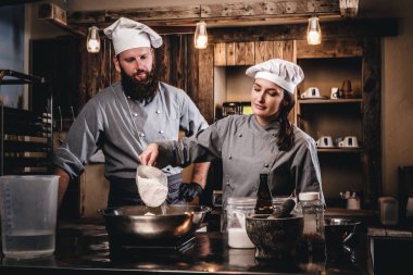 Aşçı yardımcısı un bir kasenin içine dökülen..