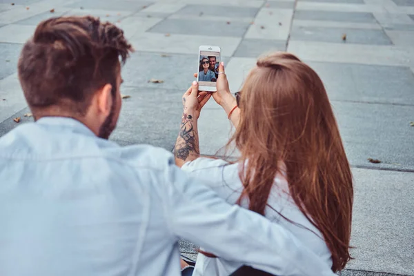 Primer plano de la foto de una joven pareja feliz hace selfie juntos al aire libre . — Foto de Stock