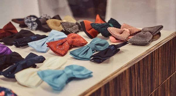 Corbata de lazo de seda de diferentes colores en la mesa en la tienda de ropa masculina . — Foto de Stock