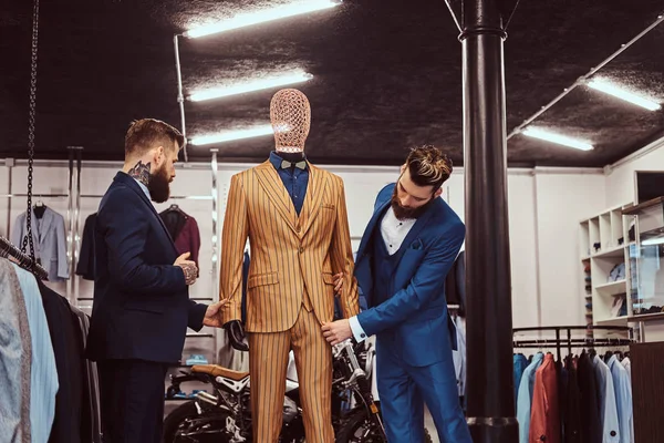Deux assistants de magasin élégants élégamment habillés travaillant dans un magasin de vêtements pour hommes . — Photo