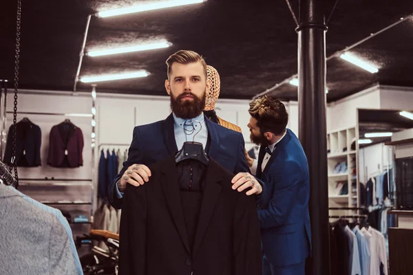 Dois assistentes de loja elegantemente vestidos trabalhando em uma loja de moda masculina . — Fotografia de Stock