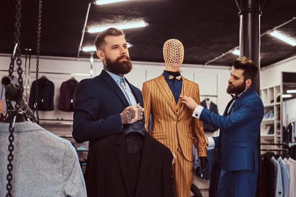 Dois assistentes de loja elegantemente vestidos trabalhando em uma loja de moda masculina . — Fotografia de Stock