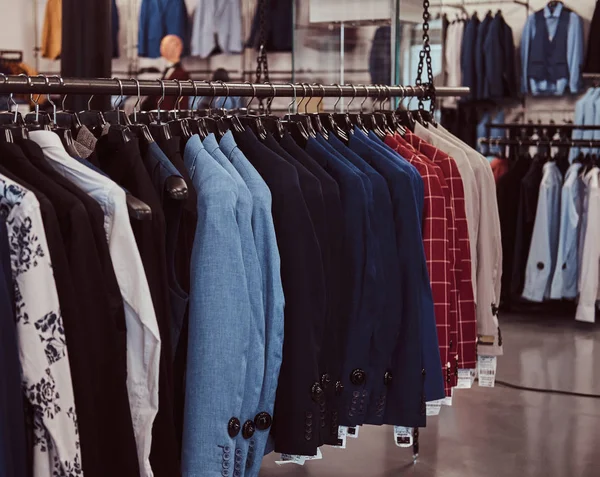 Photo d'un rack avec des vestes de costume dans un magasin de vêtements pour hommes . — Photo