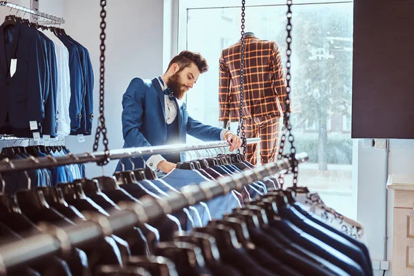 Brodaty Subiekt, ubrany w niebieski elegancki garnitur, praca w sklepie odzieży męskiej. — Zdjęcie stockowe