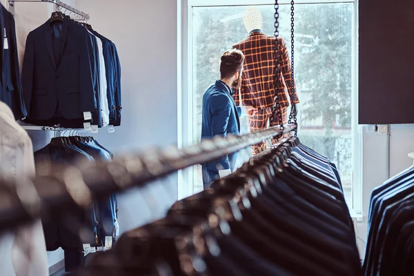 Stylový vousatý prodávající péče o oblek na manekýně v obchodě Pánské. — Stock fotografie