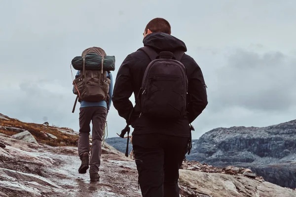 Skupina turisté s batohy, sledování v horách. — Stock fotografie