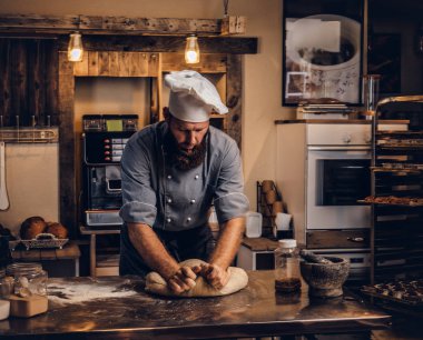 Şef mutfakta hamur yoğurma konsantre.