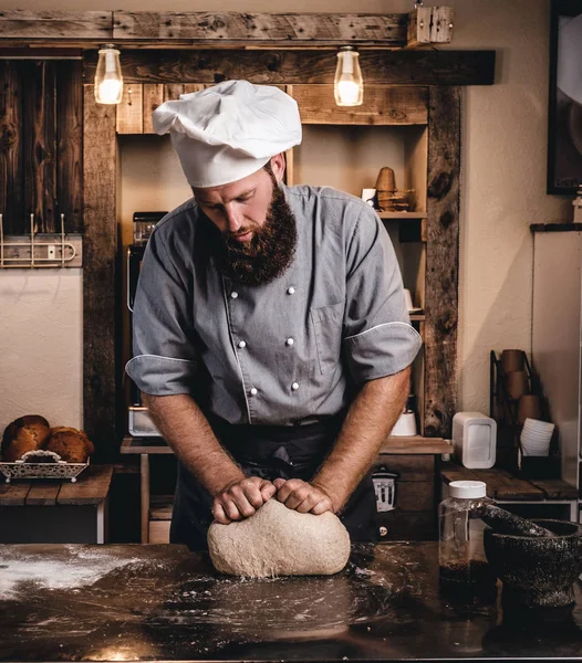 Concentrated chef kneading dough in the kitchen. — Stock Photo, Image