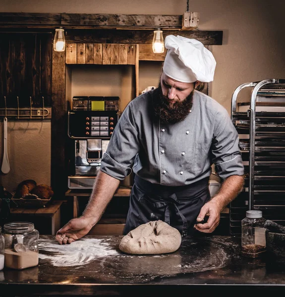 Professional baker preparing bread at a table in the bakery. — Stock Photo, Image