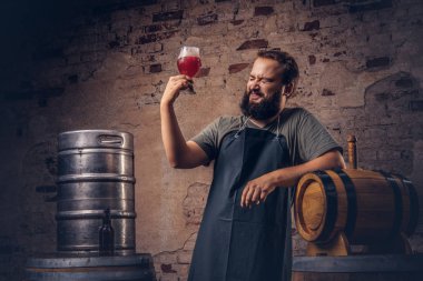 Brewer önlük ayakta yakınındaki eski bira fabrikasında varil ve içecekler zanaat bira.