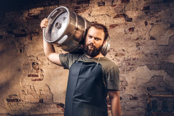 Brauer in Schürze hält Fass mit Craft Bier in Brauerei-Fabrik. — Stockfoto