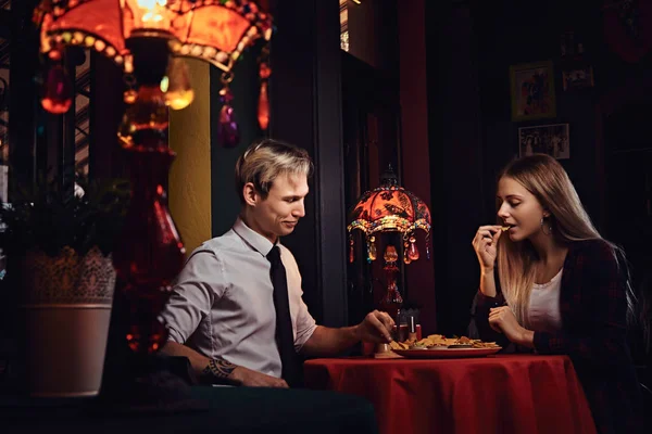 Casal atraente comer nachos durante namoro no restaurante mexicano . — Fotografia de Stock