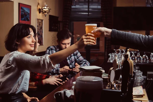 Junge multirassische Freunde in der Bar. Barmann gibt Kunden in Kneipe ein Glas Bier. — Stockfoto