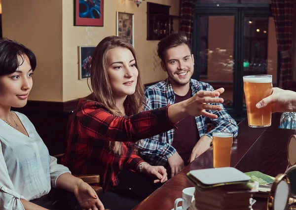 Junge multirassische Freunde in der Bar. Barmann gibt Kunden in Kneipe ein Glas Bier. — Stockfoto