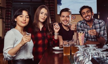 Barda oturan genç çok ırklı arkadaşlar.