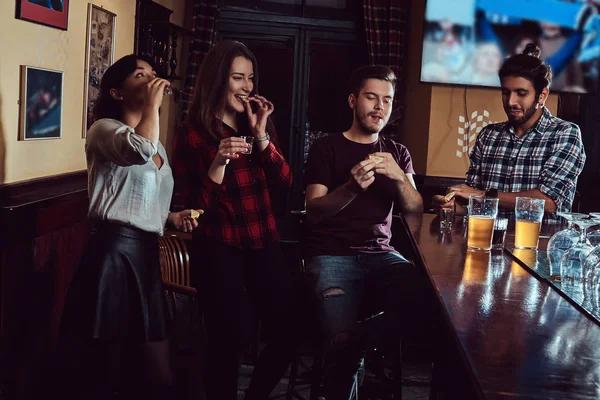 Gruppe multiethnischer Freunde, die sich an der Bar oder Kneipe ausruhen und unterhalten. — Stockfoto