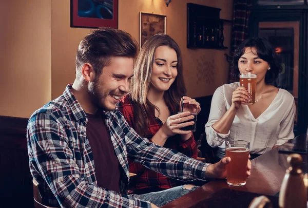 Grupo de jóvenes multirraciales sonrientes descansando en el pub . —  Fotos de Stock