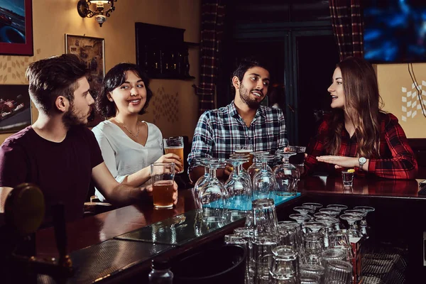 Gruppe fröhlicher multiethnischer Freunde, die sich in einer Bar oder Kneipe ausruhen und unterhalten. — Stockfoto