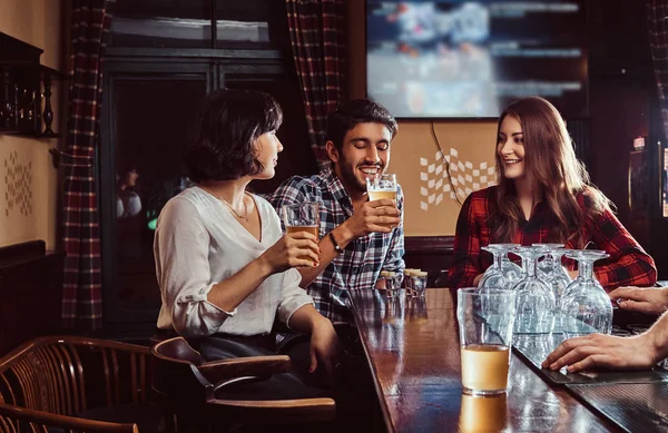 Gruppe fröhlicher multiethnischer Freunde, die sich in einer Bar oder Kneipe ausruhen und unterhalten. — Stockfoto