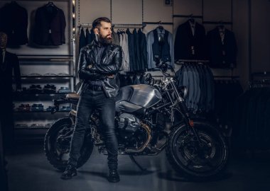 Retro yakınındaki çapraz kolları olan vahşi erkek giymiş siyah ceket poz motosiklet Erkek Giyim Mağazası, spor.
