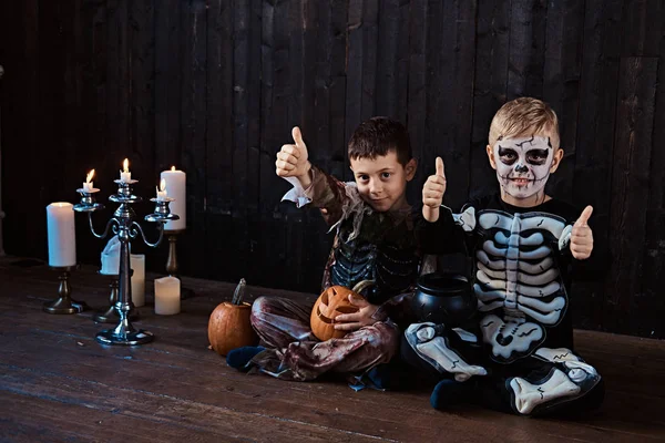 Retrato de dos colegiales guays disfrazados de miedo durante la fiesta de Halloween en una casa vieja . —  Fotos de Stock