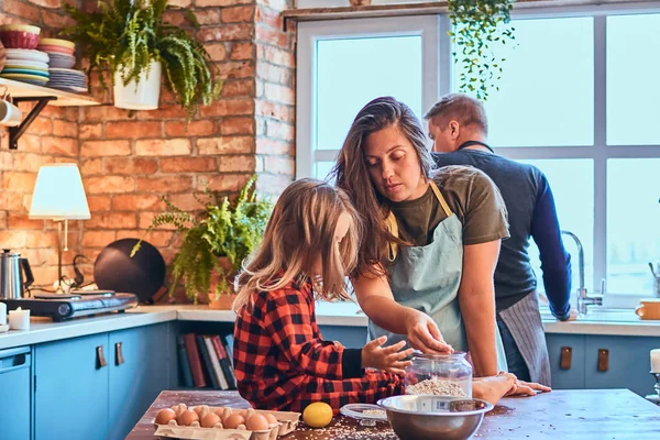 Family together cooking breakfast in loft style kitchen.