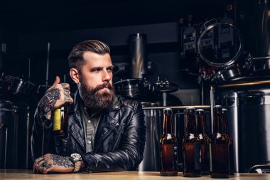 Şık sakallı motorcu indie bira sayacında bar oturan siyah deri ceket giymiş.