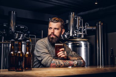 Dövmeli hippi erkek şık sakal ve saç barda oturmuş bira içme indie bira sayaç.