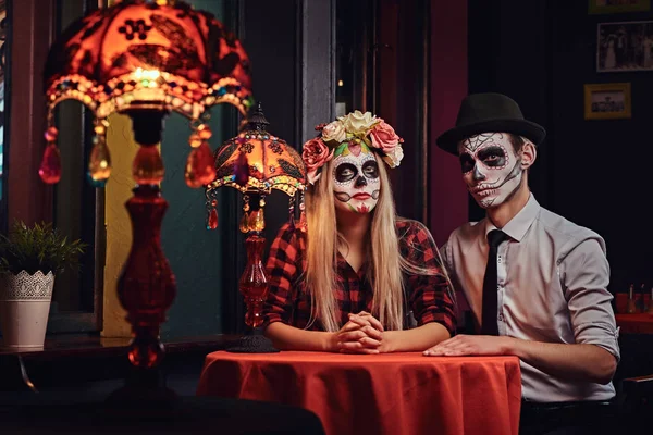 Joven pareja atractiva con maquillaje no muerto durante las citas en un restaurante mexicano . — Foto de Stock