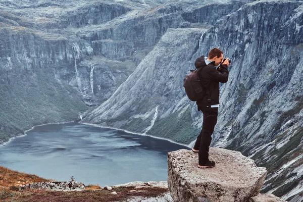 Φύση φωτογράφος τουριστικά με φωτογραφική μηχανή πυροβολεί ενώ στέκεται πάνω στο βουνό της Νορβηγίας. — Φωτογραφία Αρχείου