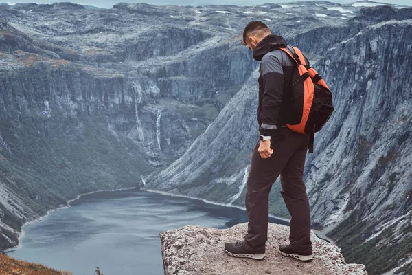 Tourist steht auf dem Gipfel des Berges mit einem atemberaubenden Blick auf den norwegischen Fjord. — Stockfoto