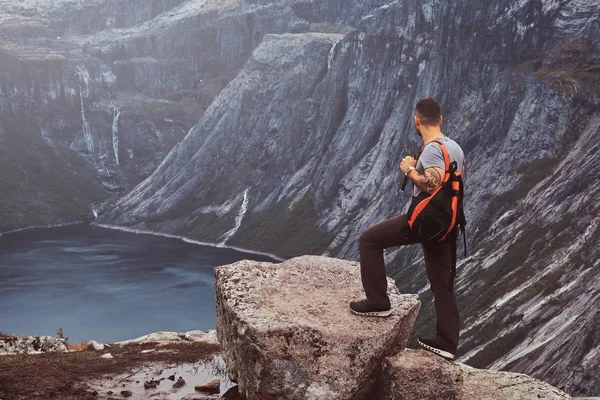 Dağın zirvesine Norveç fiyordu şaşırtıcı bir görünümünü üzerinde turist duruyor. — Stok fotoğraf