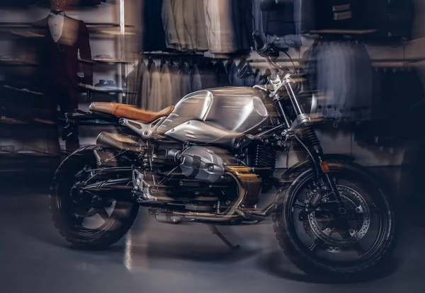 Foto di una moto sportiva retrò al negozio di abbigliamento maschile con effetto luce di movimento . — Foto Stock